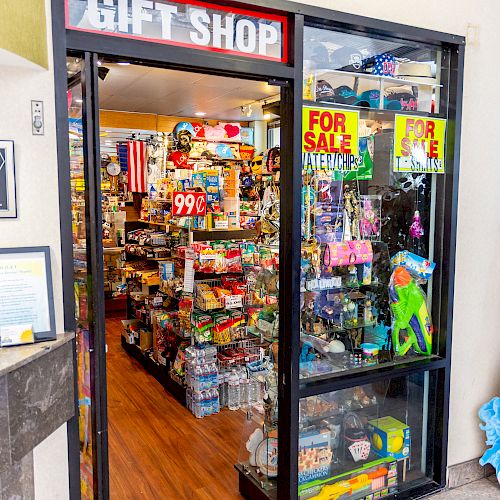 Image of a small gift shop with a variety of items on display, including toys, souvenirs, and signs saying 